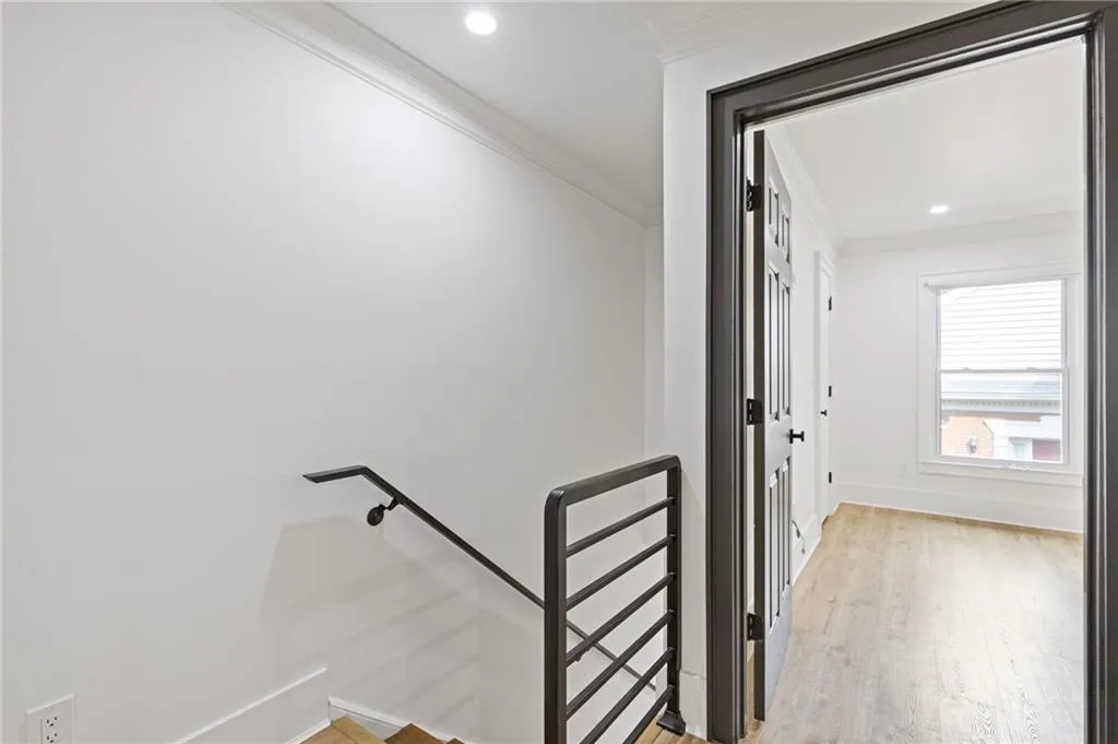 Staircase featuring wood finished floors, ornamental molding, and recessed lighting