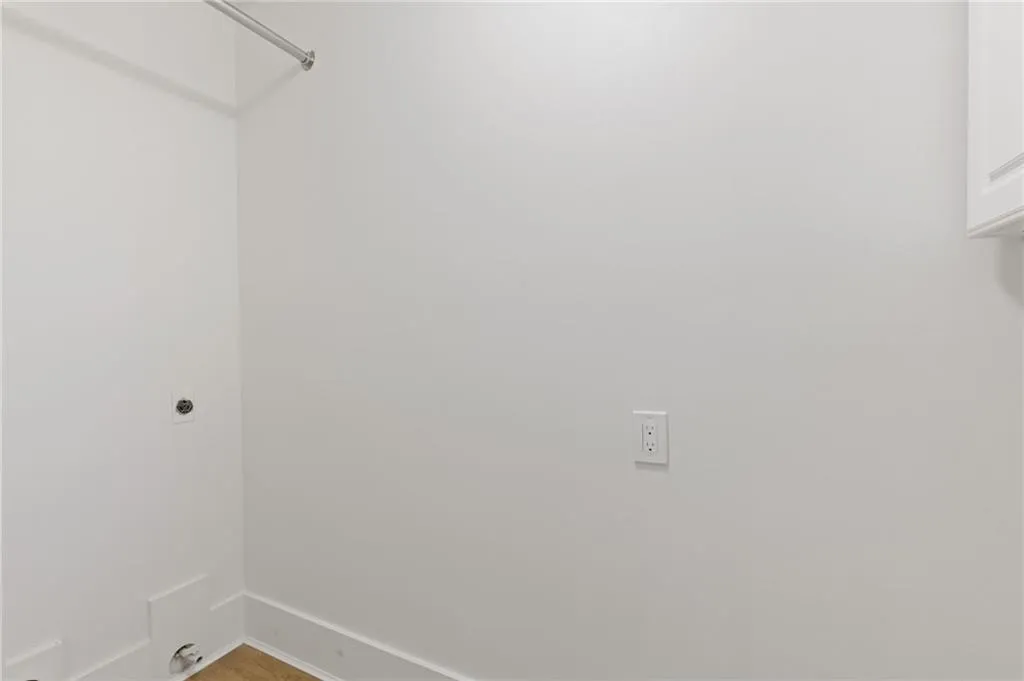 Washroom with baseboards and hookup for an electric dryer