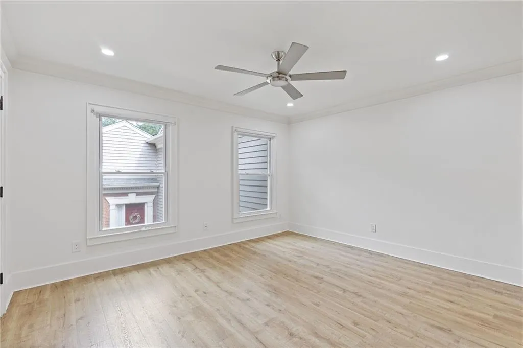 Empty room featuring ornamental molding, light wood-style floors, recessed lighting, and a ceiling fan