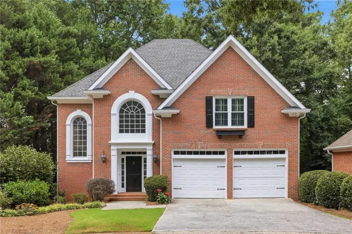 Brick exterior with a gabled roofline, featuring a double arched window facade and a matching arched entry