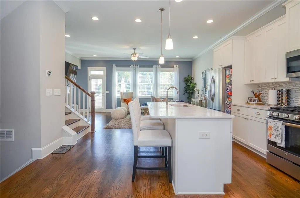 Kitchen with ornamental molding, tasteful backsplash, hanging light fixtures, stainless steel appliances, and ceiling fan