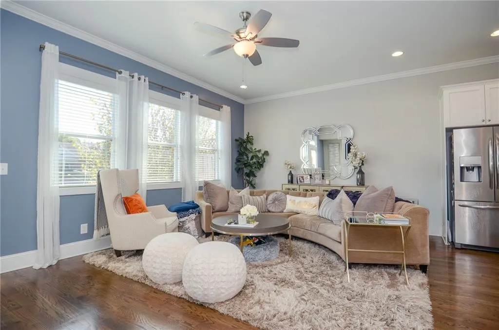 Living room with crown molding, dark wood finished floors, ceiling fan, and recessed lighting