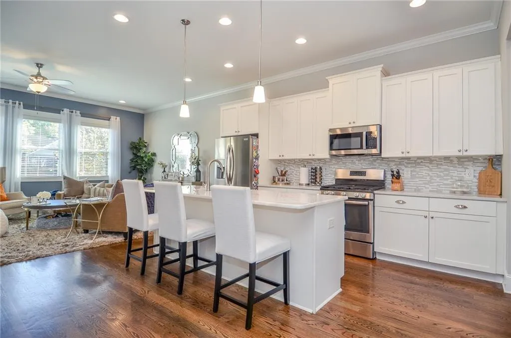 Kitchen with ornamental molding, stainless steel appliances, open floor plan, a breakfast bar area, and backsplash