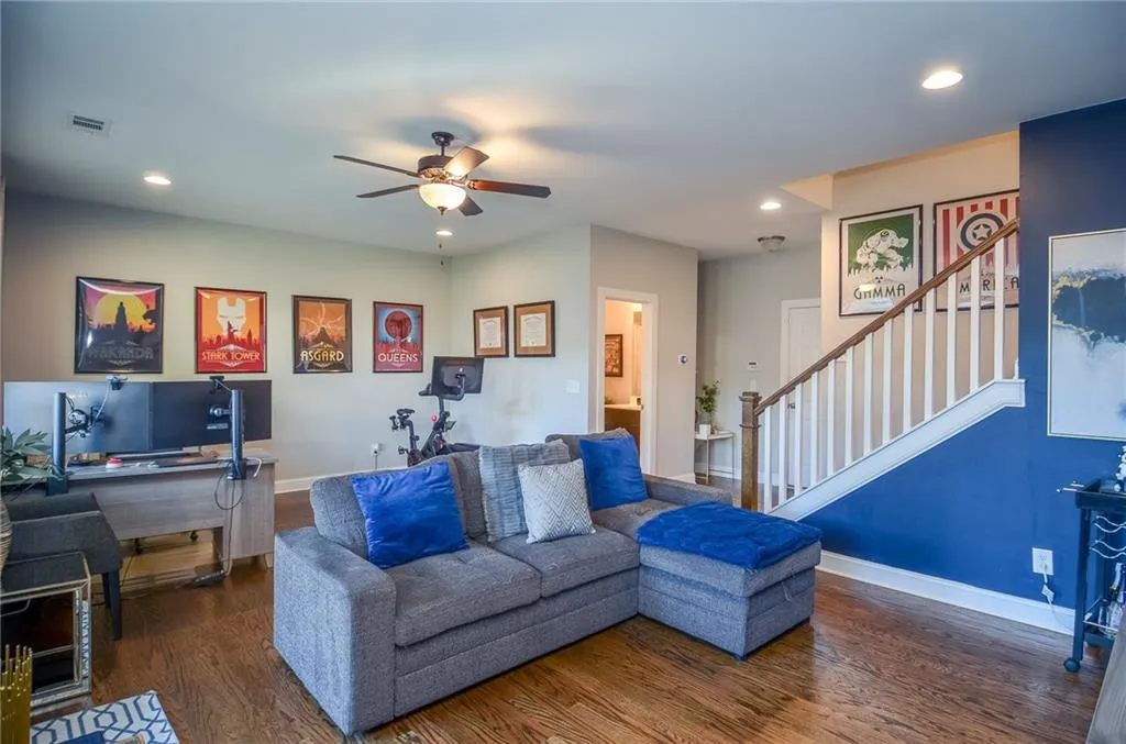 Living area with dark wood finished floors, a desk, stairs, recessed lighting, and ceiling fan