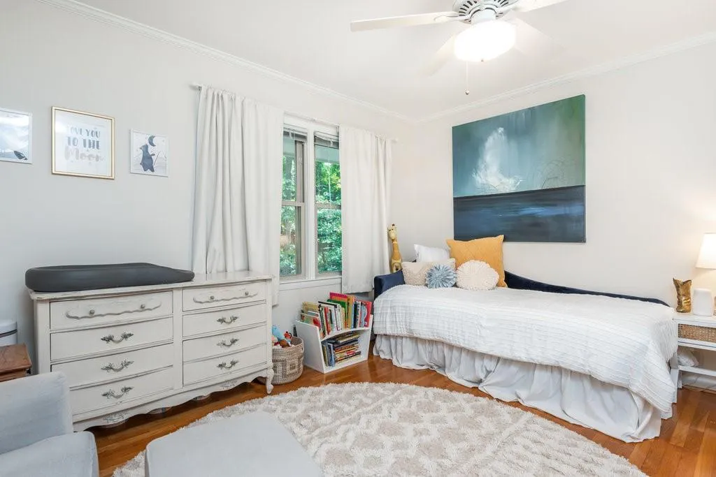 Bedroom with ornamental molding, wood-type flooring, and ceiling fan
