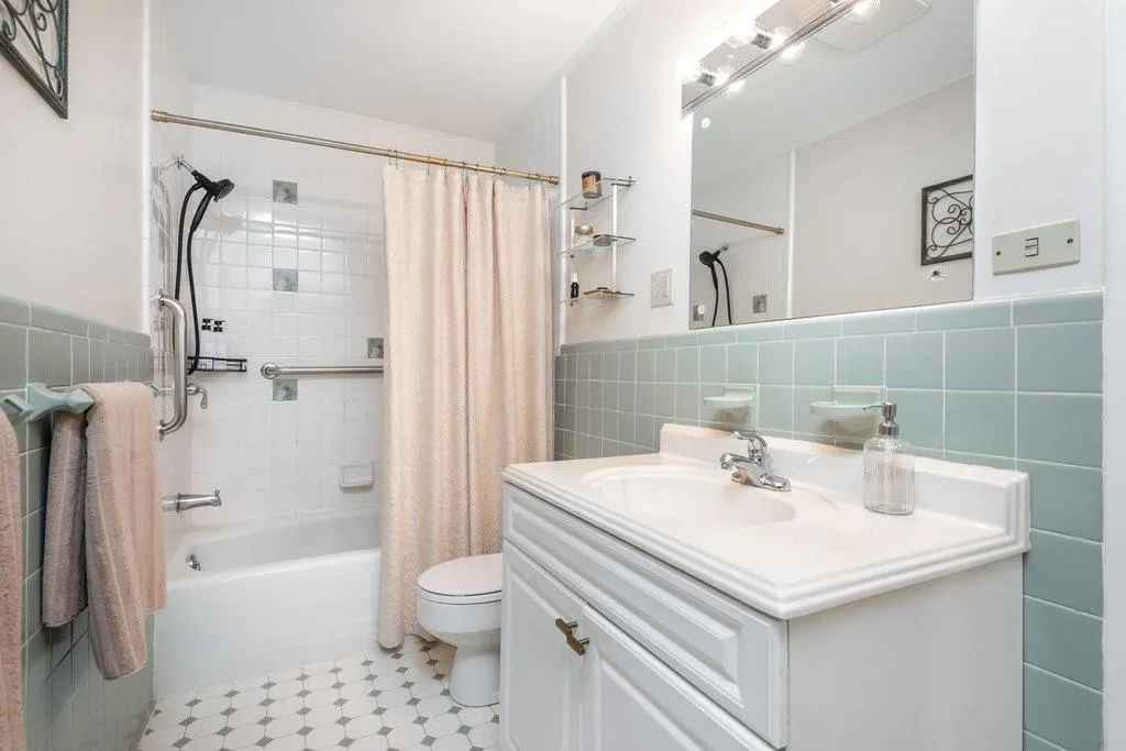 Full bathroom with shower / bath combo, toilet, tile walls, tasteful backsplash, and vanity