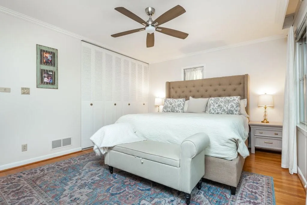 Bedroom with crown molding, ceiling fan, hardwood / wood-style floors, and a closet