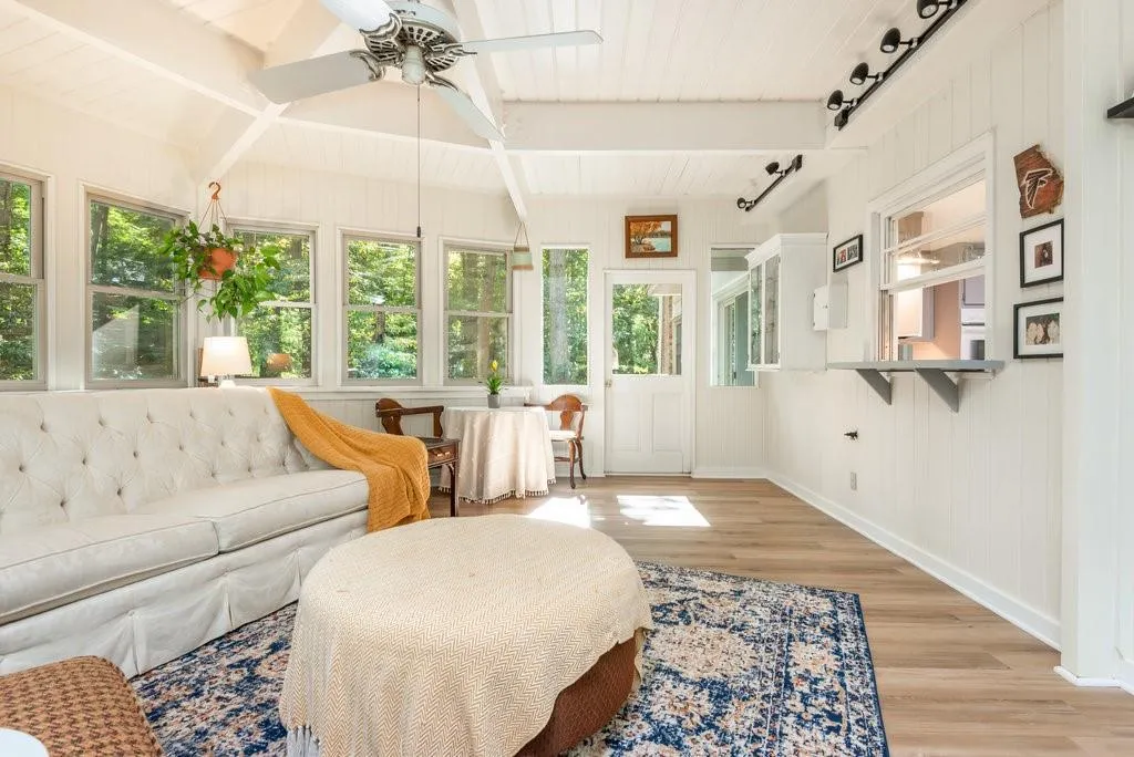 Sunroom with track lighting, beam ceiling, and ceiling fan