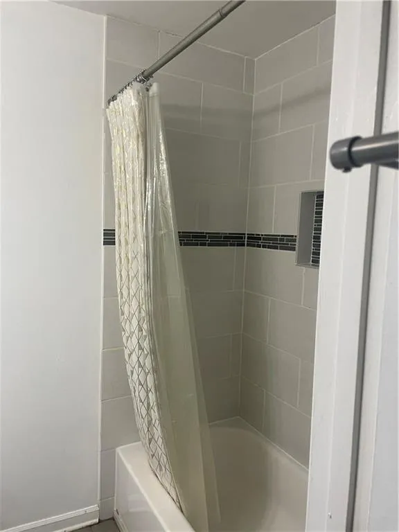 Full bath featuring shower / tub combo with curtain