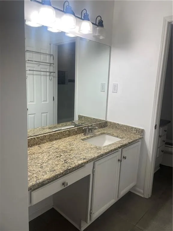 Bathroom featuring vanity and dark tile patterned floors
