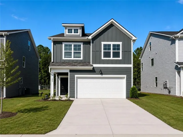 Contemporary two-story home featuring a dark gray vertical and horizontal siding facade
