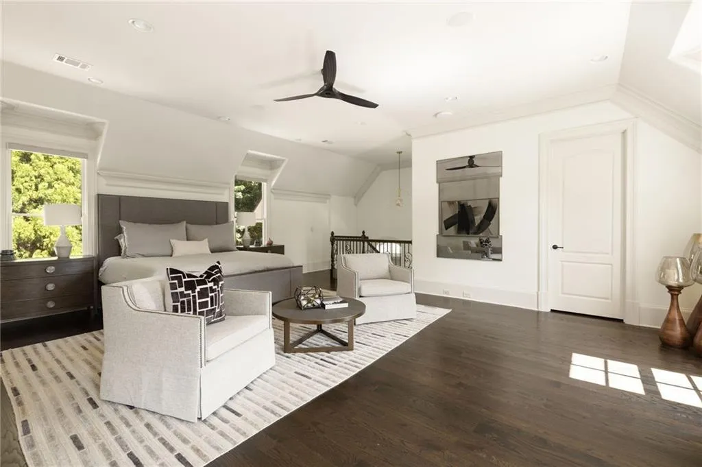 Expansive room featuring dark wood-finish flooring, recessed lighting, a modern ceiling fan, and multiple windows