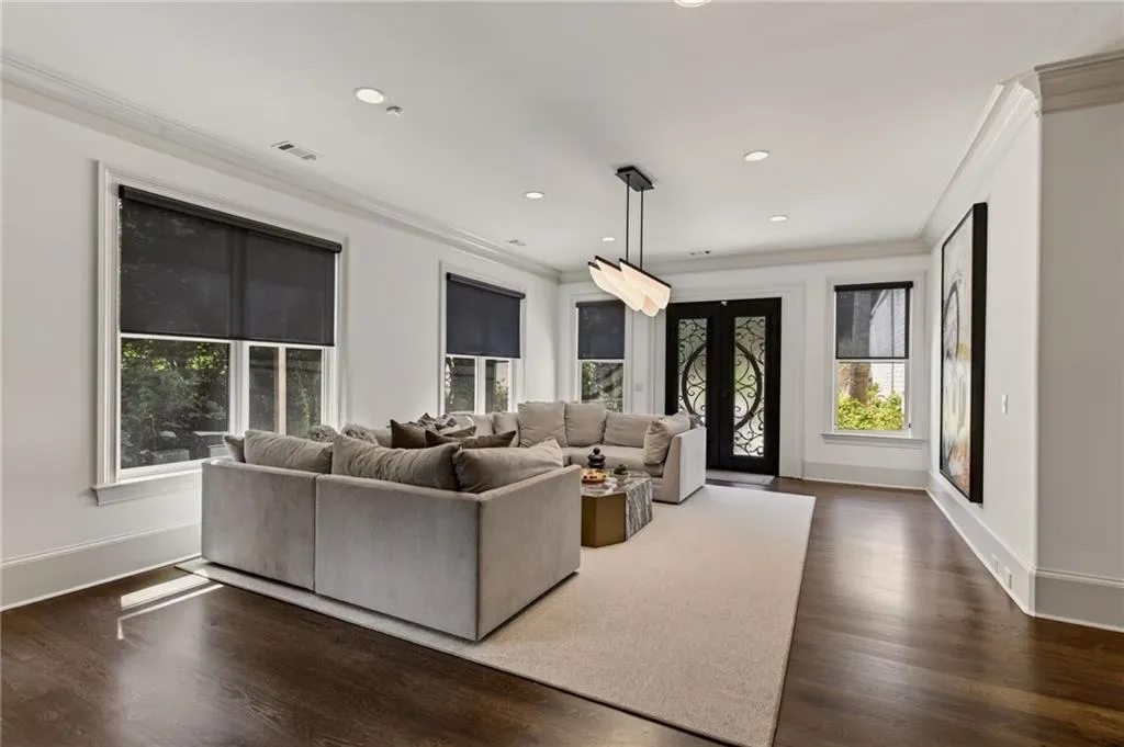 Dark wood-finish flooring, white walls, and crown molding
