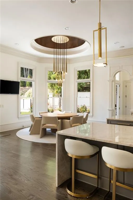 Hardwood flooring throughout, a decorative ceiling medallion, and extensive crown molding