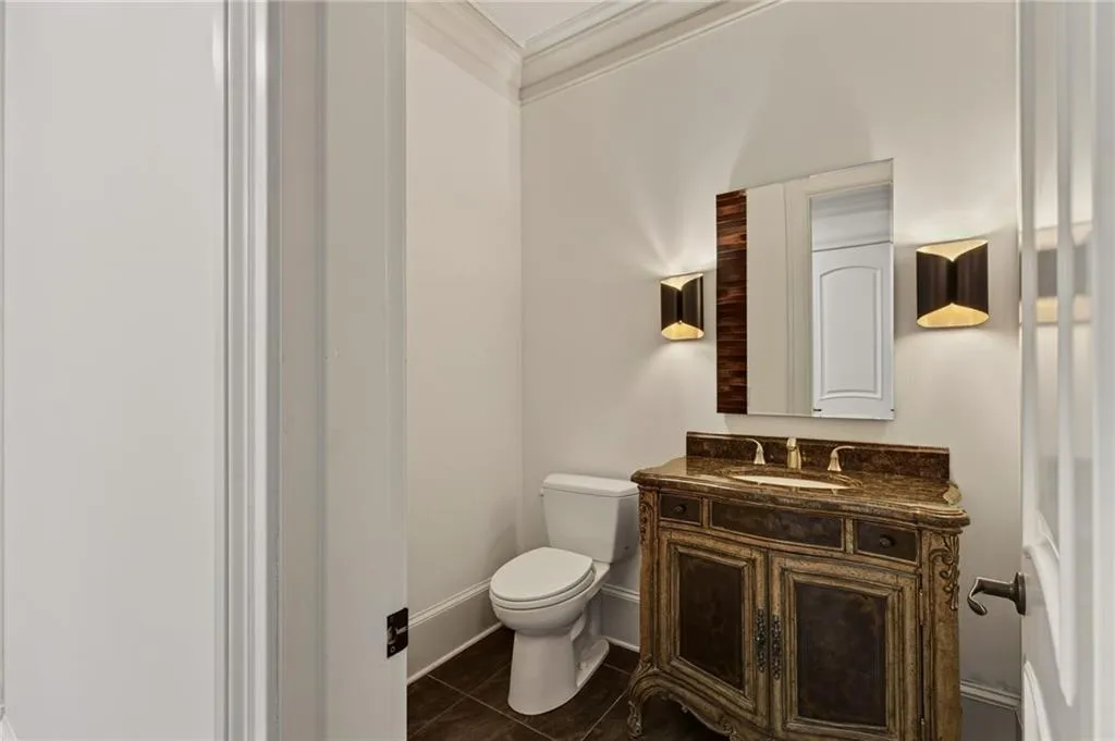 Ornate vanity with a stone countertop, featuring a built-in sink and wall-mounted mirror