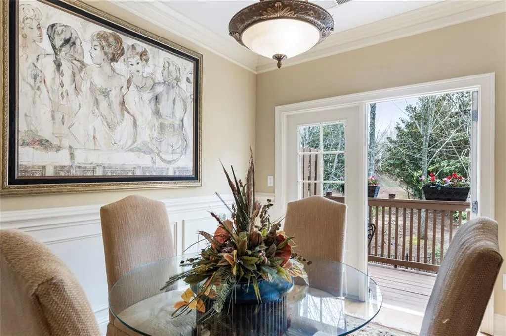 Dining space featuring crown molding, wainscoting, and a decorative wall