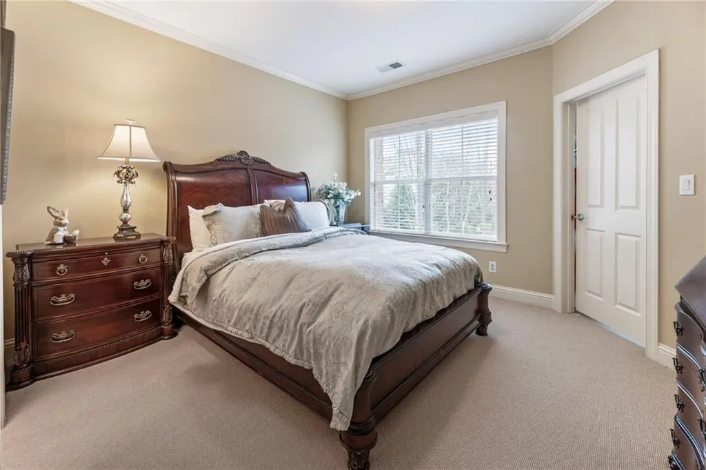 Carpeted bedroom featuring ornamental molding and baseboards