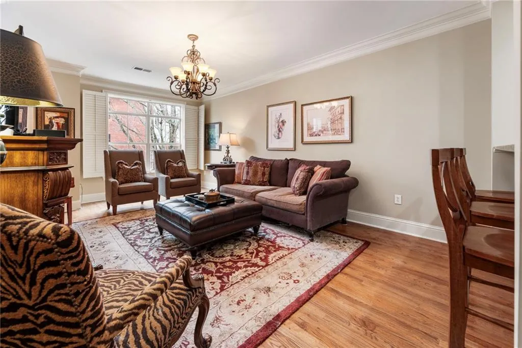 Living area featuring crown molding, hanging lights, and light wood finished floors