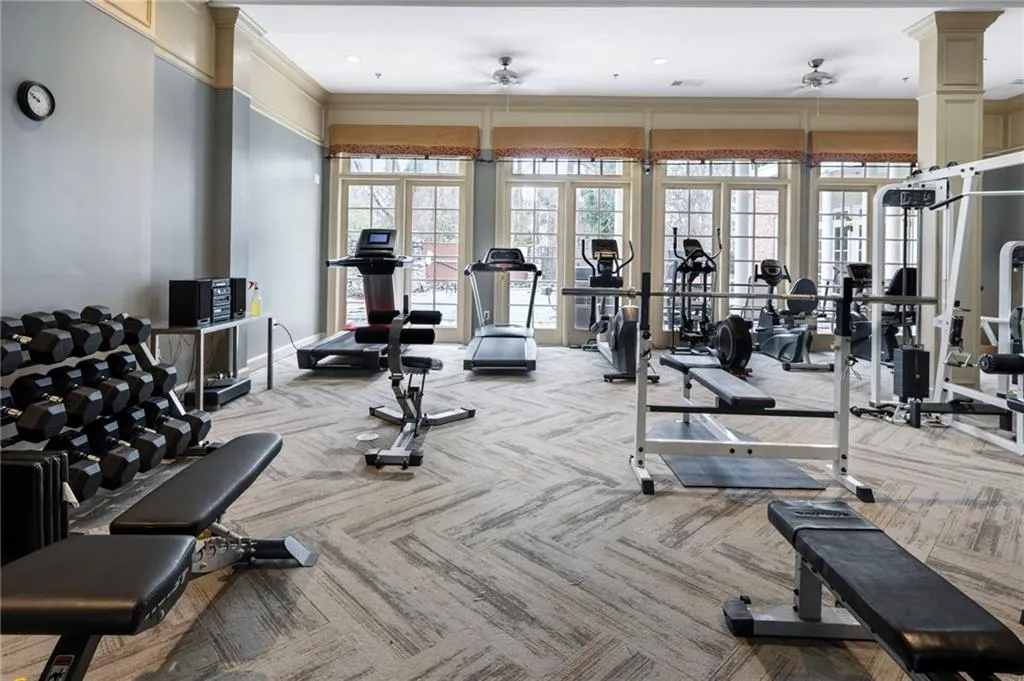 Exercise room with crown molding and a ceiling fan