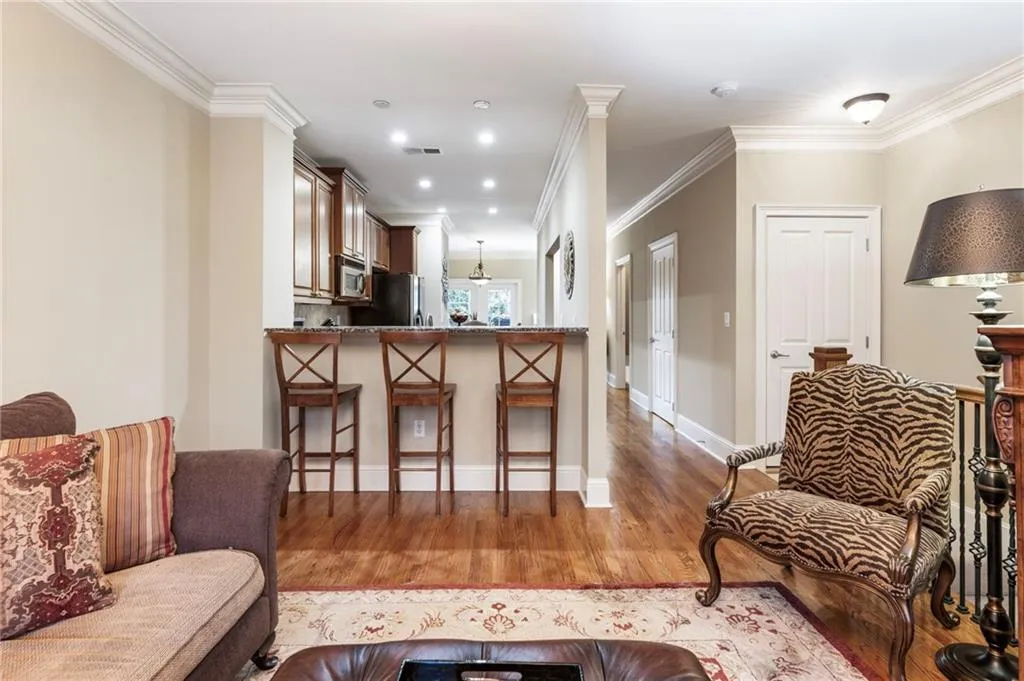 Living area with light wood-style floors, crown molding, and recessed lighting