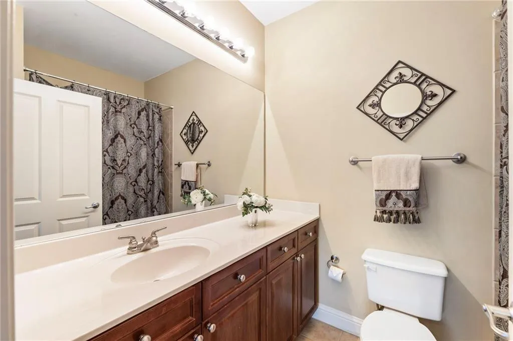 Full bath featuring curtained shower and vanity