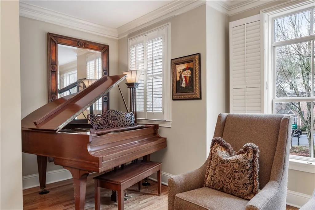 Living area with ornamental molding, light wood finished floors, and plenty of natural light