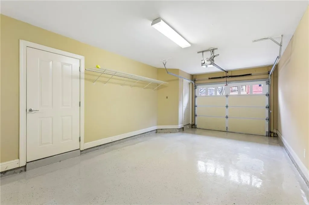 Garage with baseboards and a garage door opener