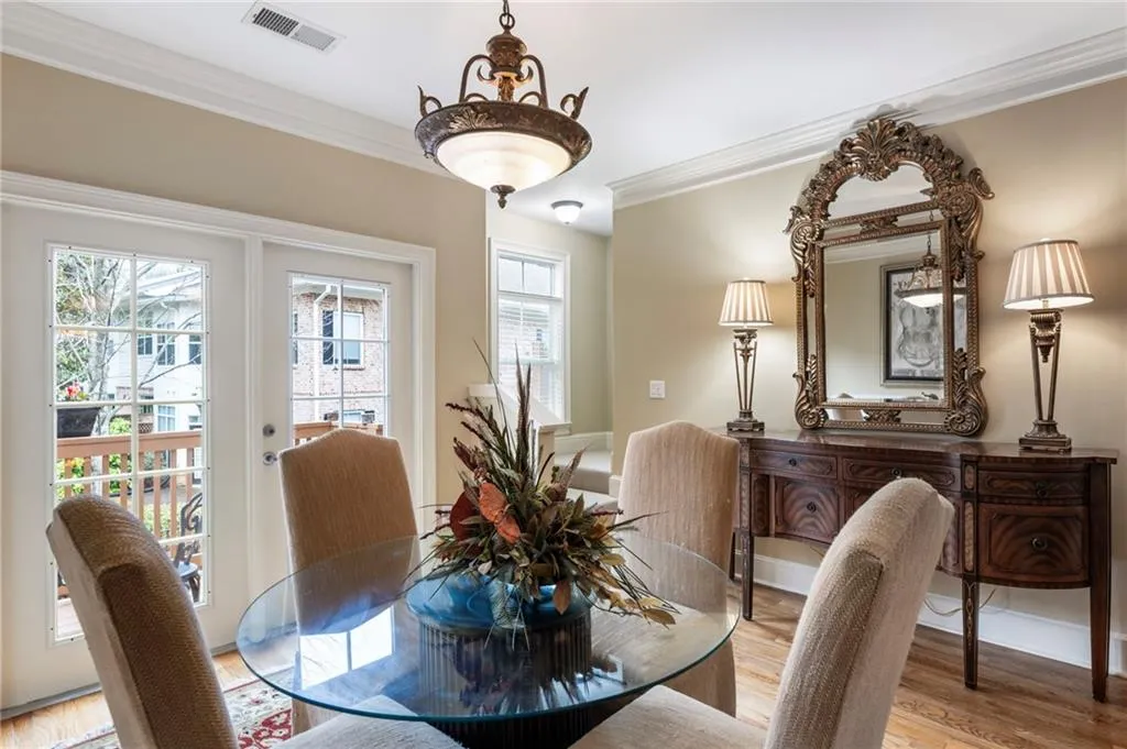 Dining room with light wood finished floors, ornamental molding, and french doors