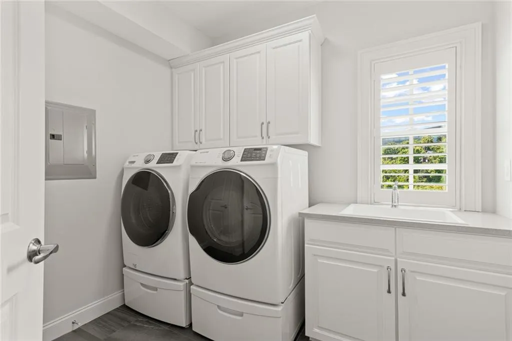 Level 3 _ primary level _ Daylight Laundry Room features sink, upper cabinets and linen closet