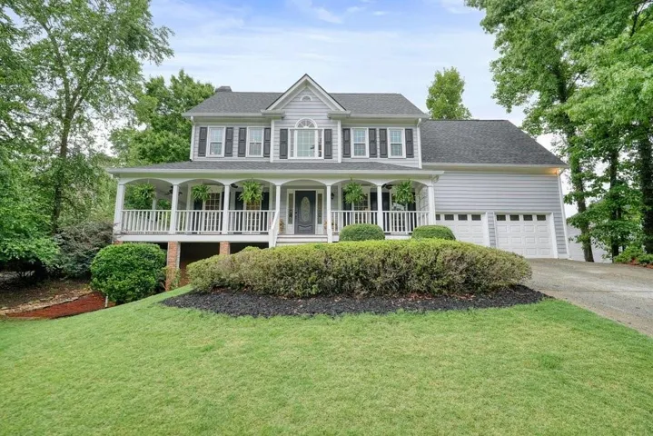 Classic two-story Colonial featuring a brick and vinyl exterior with a prominent front-gable design