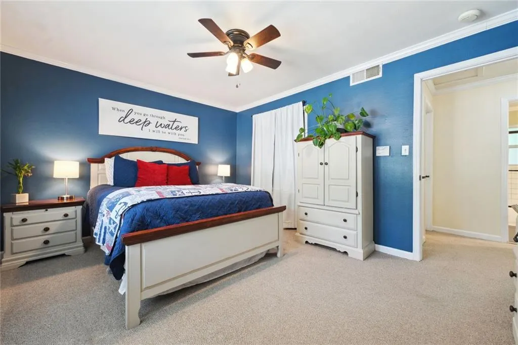 Bedroom featuring ceiling fan, carpet, and crown molding