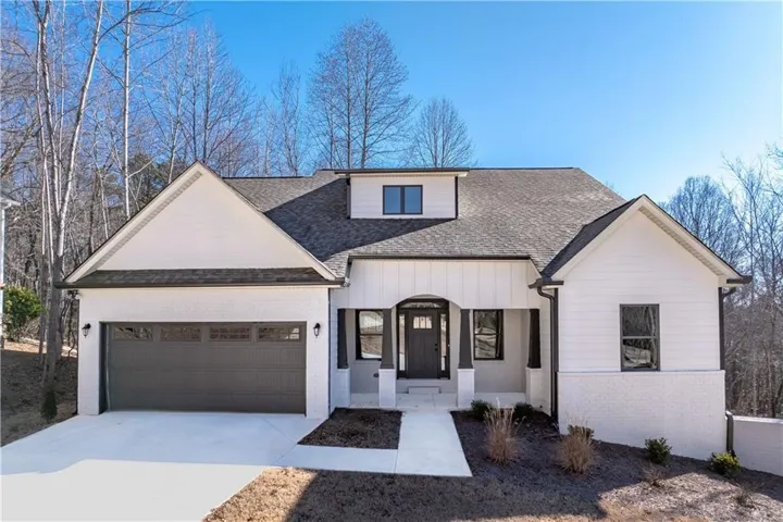 Contemporary-style residence featuring white siding and brick accents