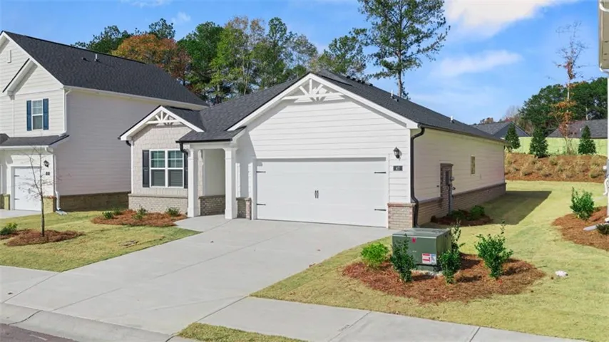 View of front of home with brick siding, a front yard, concrete driveway, and an attached garage