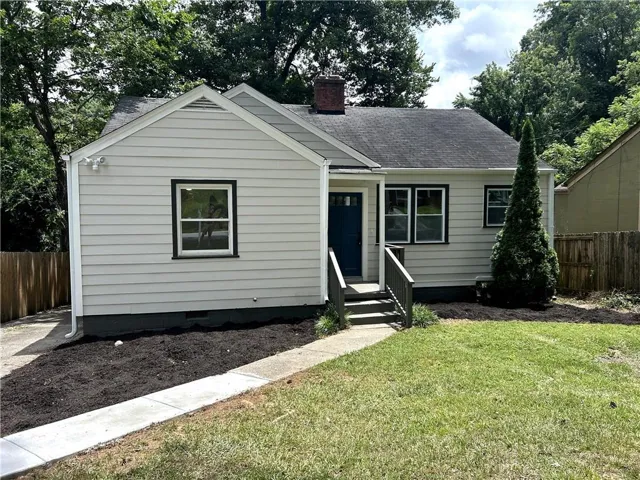 Light-colored siding exterior featuring a dark blue entry door and white-framed windows