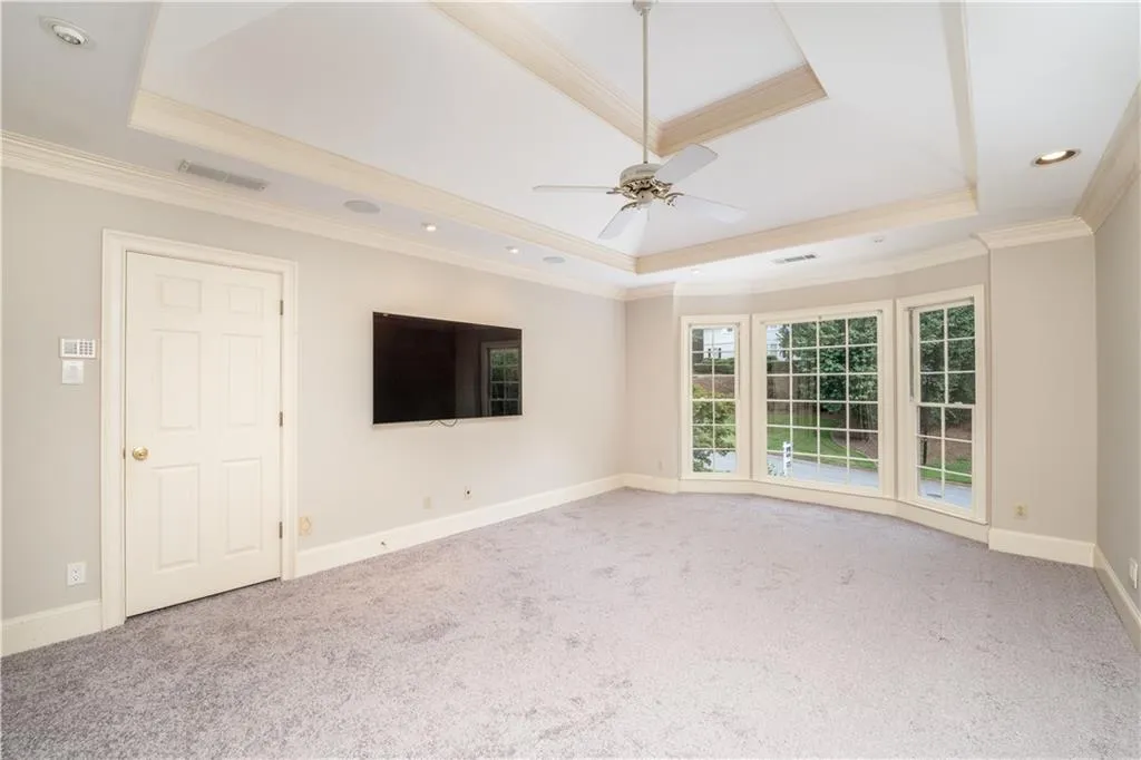 King size primary bedroom with tray ceiling and new carpet King size primary bedroom with tray ceiling and new carpet