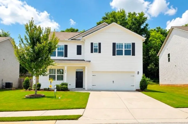 Modern two-story residence with white siding, black shutters, and a two-car garage