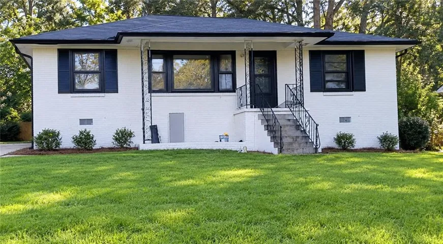 White brick exterior with a dark roof and black window shutters