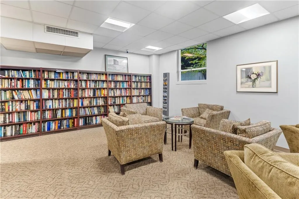 Sitting room with a paneled ceiling and wall of books