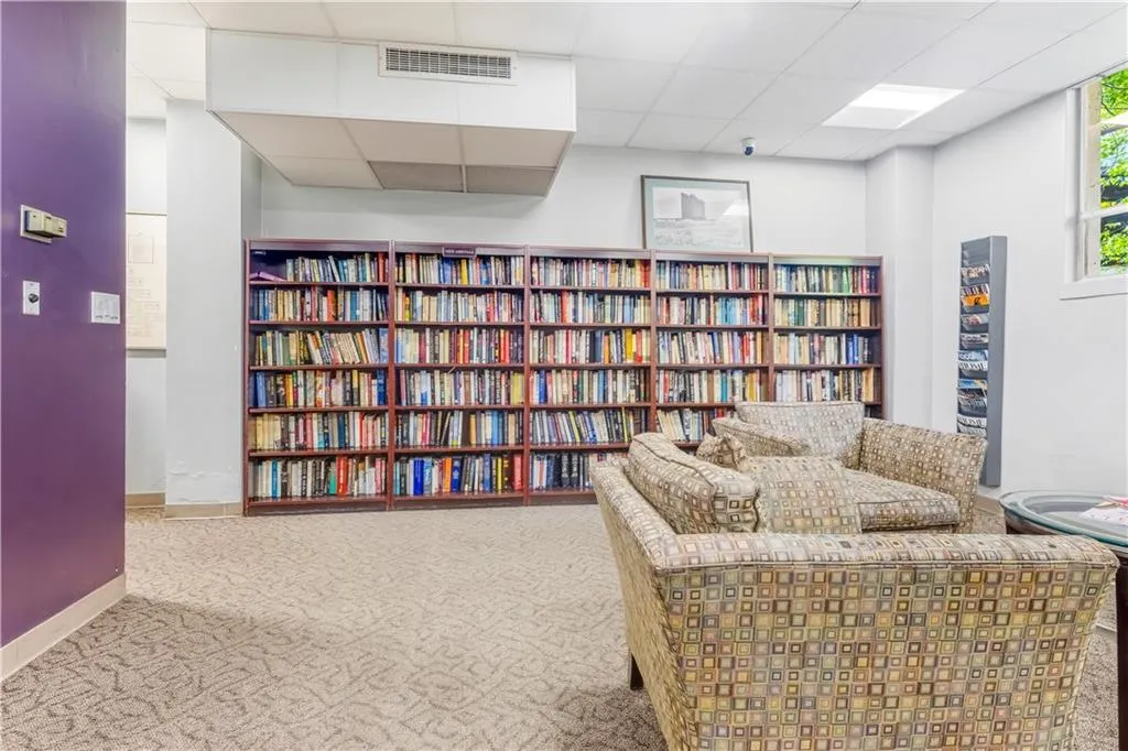 Sitting room featuring a drop ceiling and bookshelves