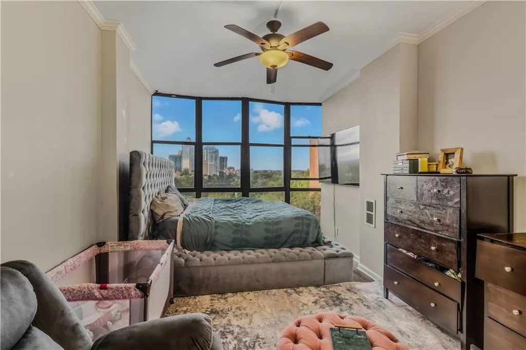 Bedroom with crown molding, expansive windows, and ceiling fan