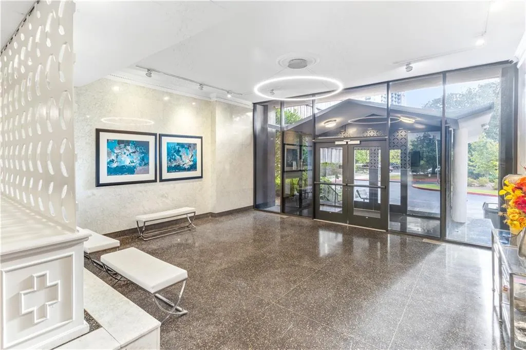 Community lobby featuring rail lighting and floor to ceiling windows