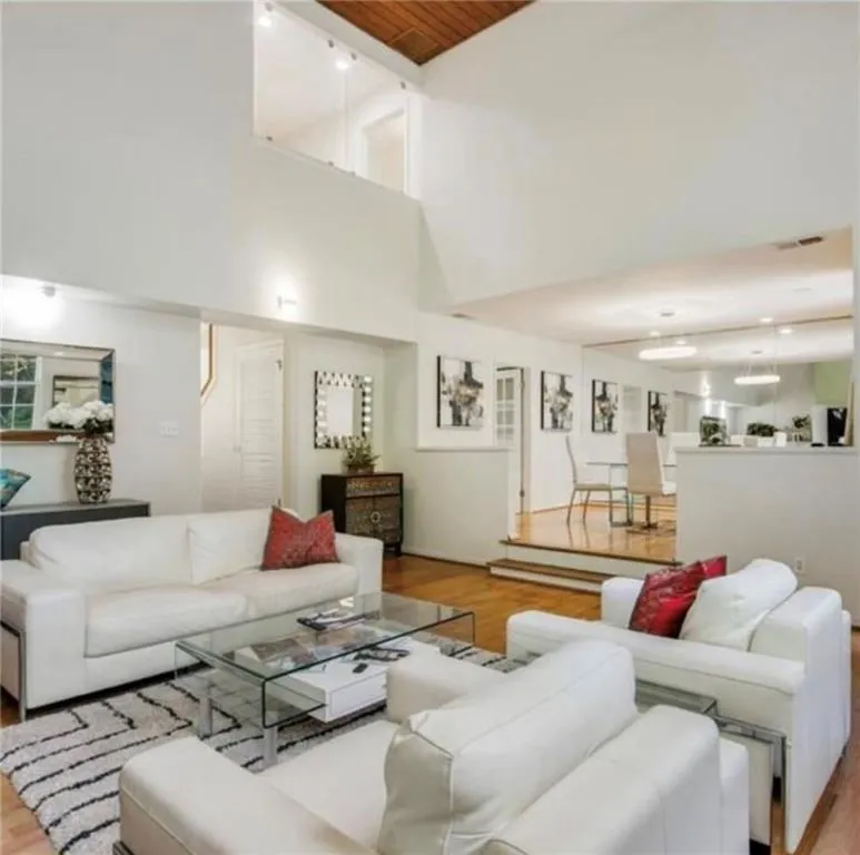Living room with wood finished floors, wood ceiling, and a towering ceiling