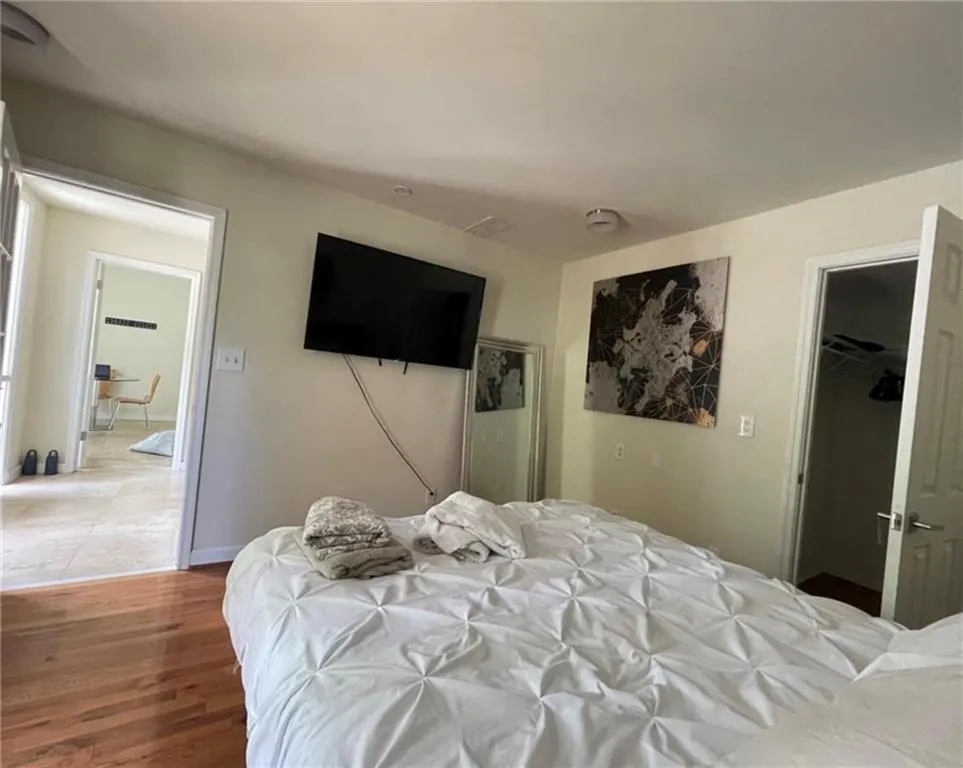 Bedroom featuring wood finished floors and a spacious closet