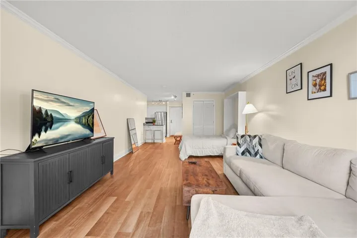 Living room featuring crown molding and light wood-style floors