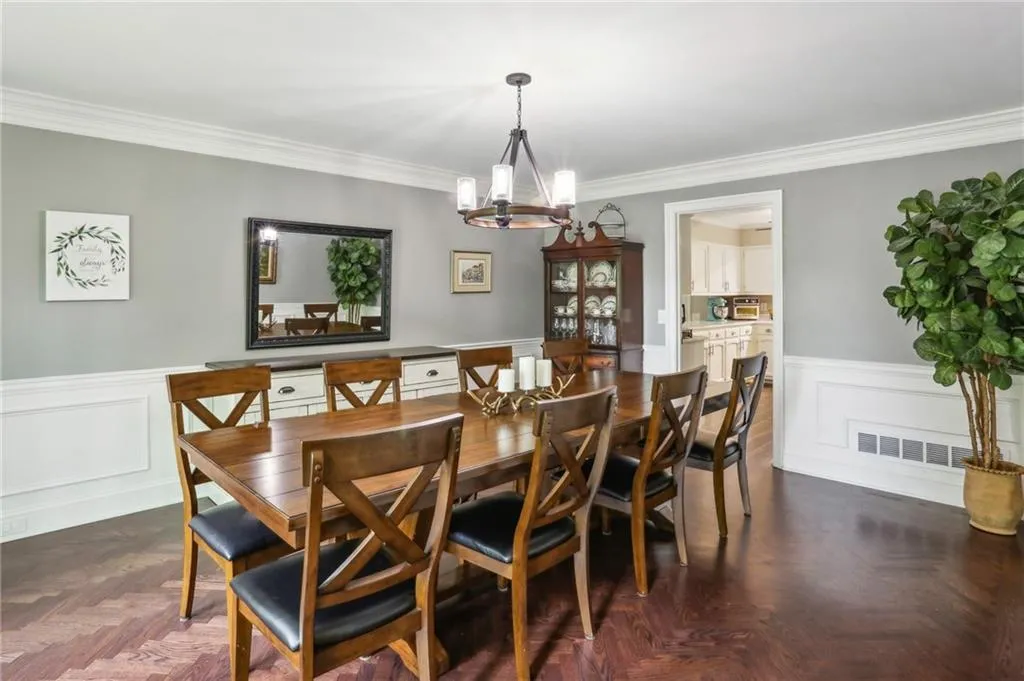 From the front door, to the left you will find this large dining room featuring beautiful herringbone hardwood floors