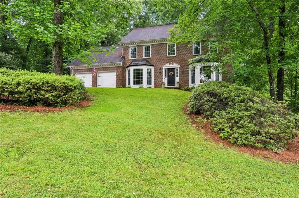 Colonial house featuring a front yard and a garage