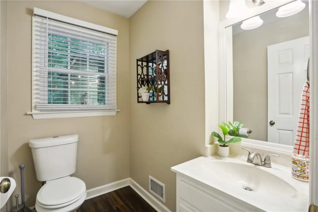 Bathroom with hardwood / wood-style flooring, toilet, and large vanity