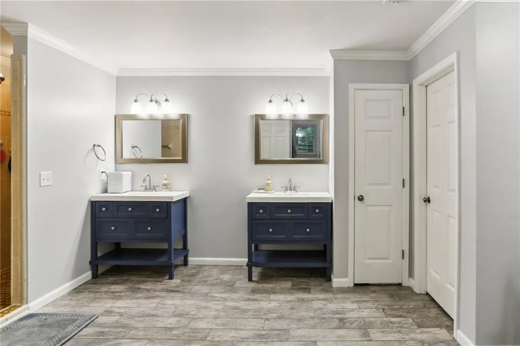 Bathroom with ornamental molding and double sink vanity