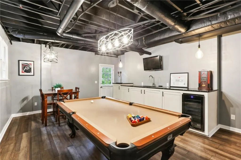Playroom featuring dark hardwood / wood-style flooring, sink, wine cooler, and pool table