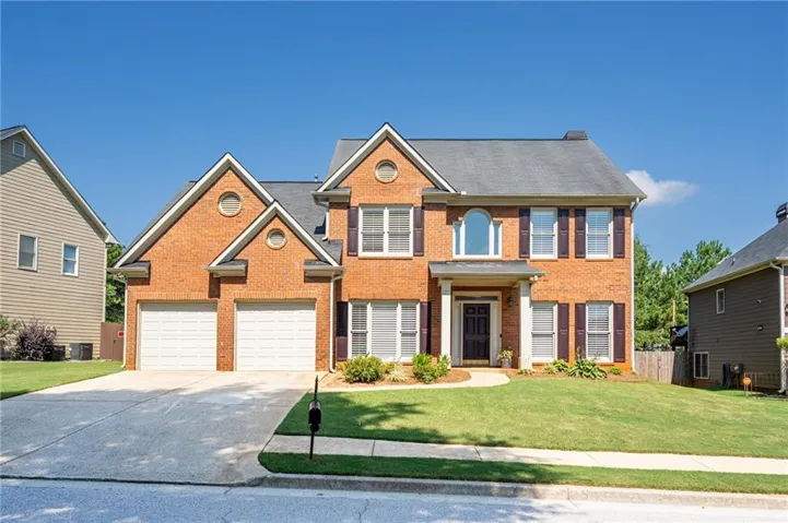Brick exterior with a gabled roofline, featuring a covered entry and a two-car garage